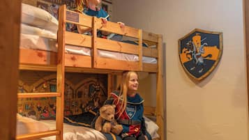 Una cama litera con un mural decorativo y un escudo.