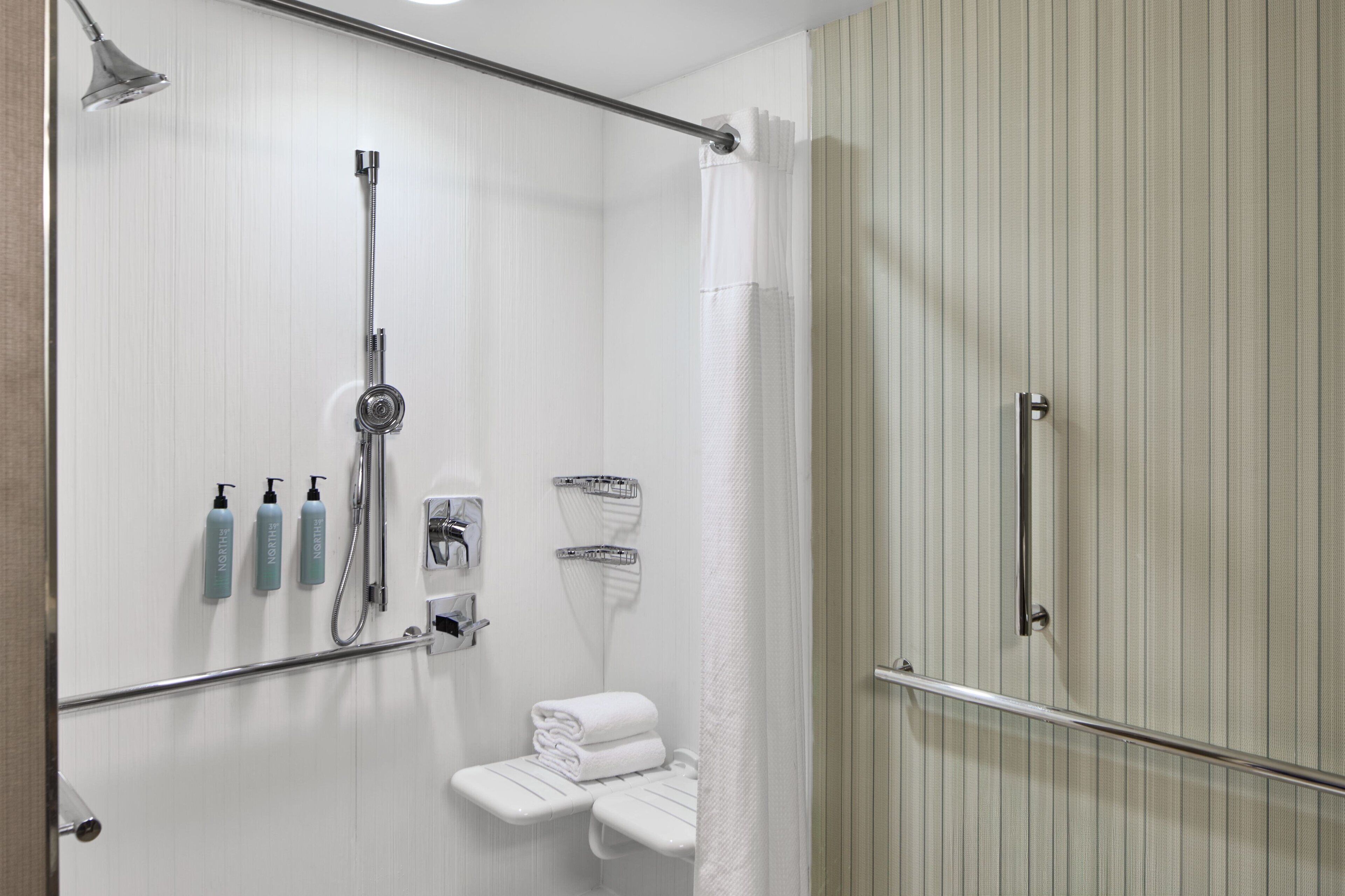 Un baño moderno con ducha, toallero y artículos de aseo.