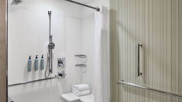 Un baño moderno con ducha, toallero y artículos de aseo.