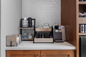 A kitchenette with a coffee machine, a coffee press, a toaster, and a small wooden cabinet. - Hilton Garden Inn Nashville Brentwood (Brentwood)
