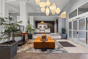 A modern lobby with a reception desk, seating area, and potted plants. - Hilton Garden Inn Nashville Brentwood (Brentwood)