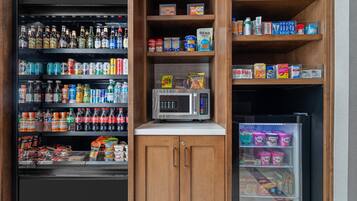 A vending machine with a microwave, various food and drink options, and a refrigerated section.