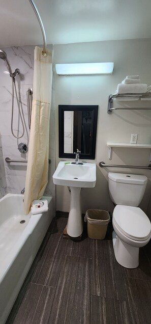 Un baño con bañera, lavamanos, inodoro y ducha.