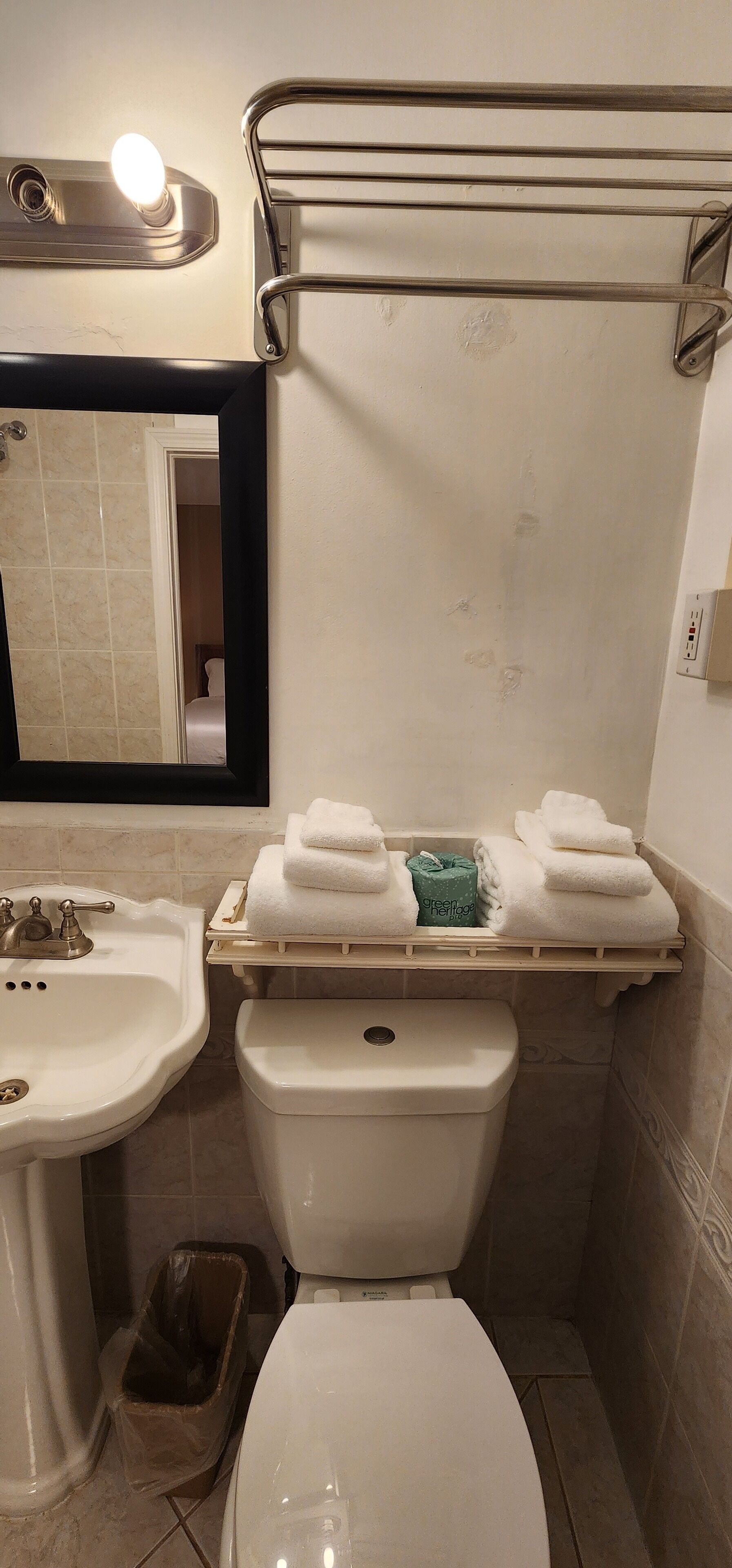 A bathroom with a sink, toilet, and towel rack.
