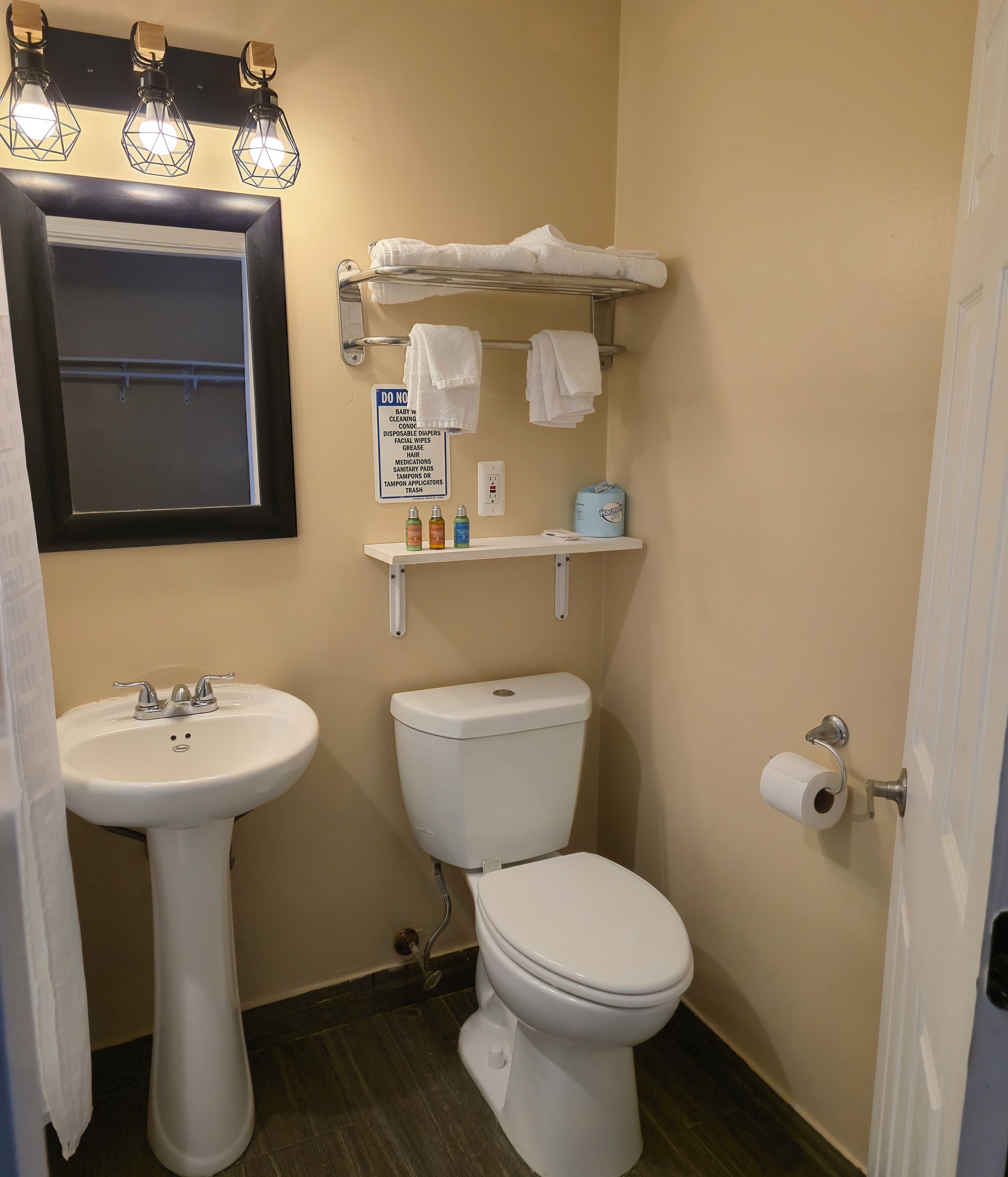 A bathroom with a sink, toilet, and towel rack.