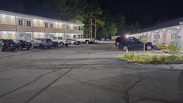Un motel con varias habitaciones, un estacionamiento y un pequeño jardín.
