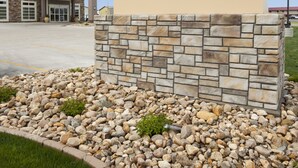 A GrandStay Hotel & Suites sign with a stone base and a clear blue sky in the background. - GrandStay Hotel and Suites (Valley City)