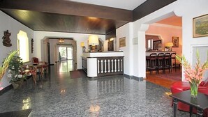 A lobby with a reception desk, seating area, and a dining space. - Hotel Leopold (Munich)