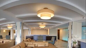 A spacious living area with a large sofa set, a dining table, and a kitchen area visible through an open door. - Aqua Blue Hotel (Narragansett)