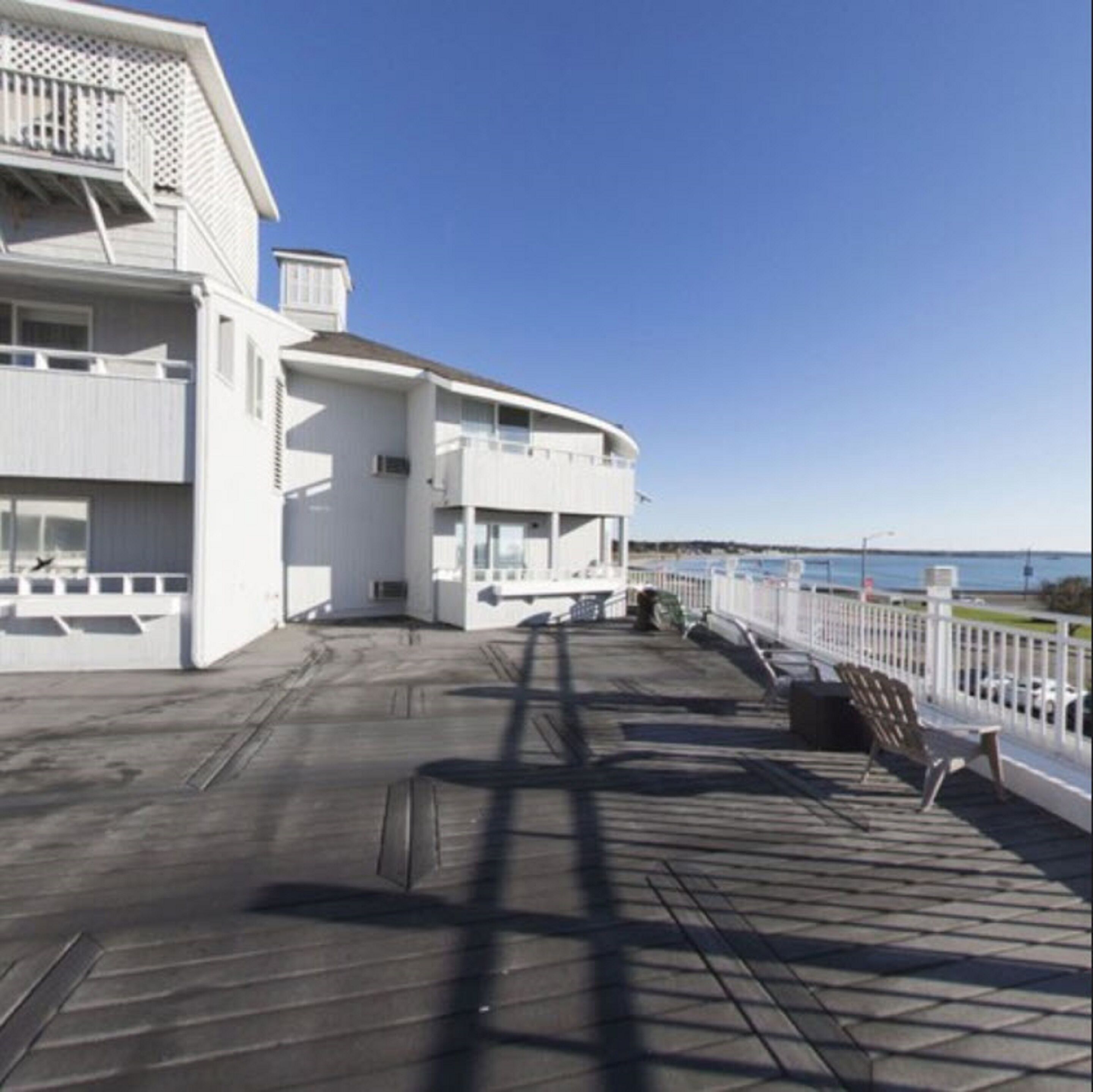 A white building with a flat roof and a balcony.