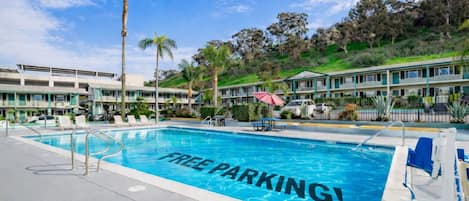 A hotel pool with a sign that says "FREE PARKING!"