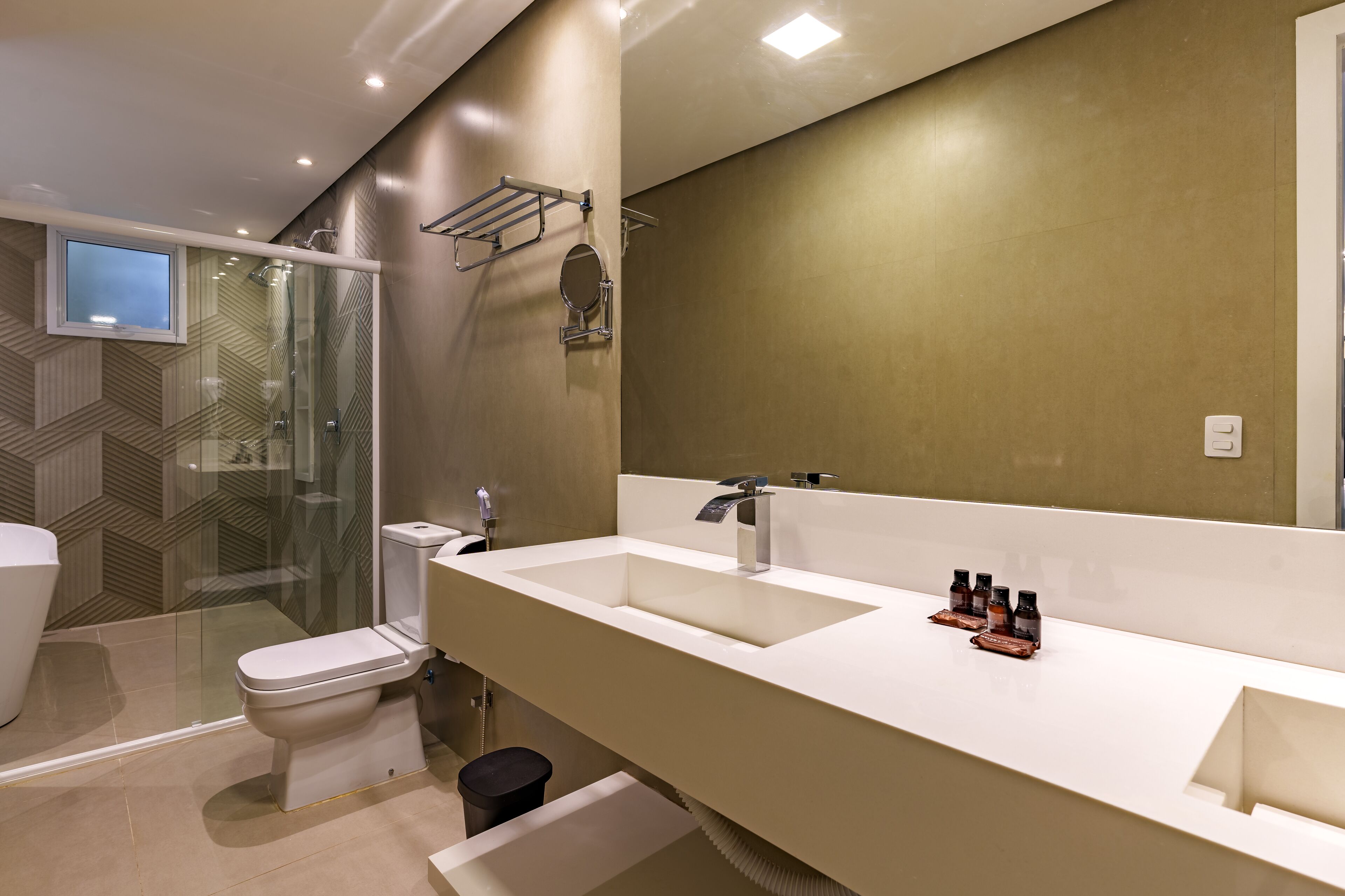 Un baño moderno con un espejo grande, dos lavamanos y una ducha.