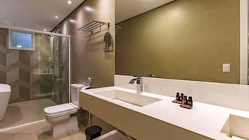 A modern bathroom with a large mirror, two sinks, and a shower.