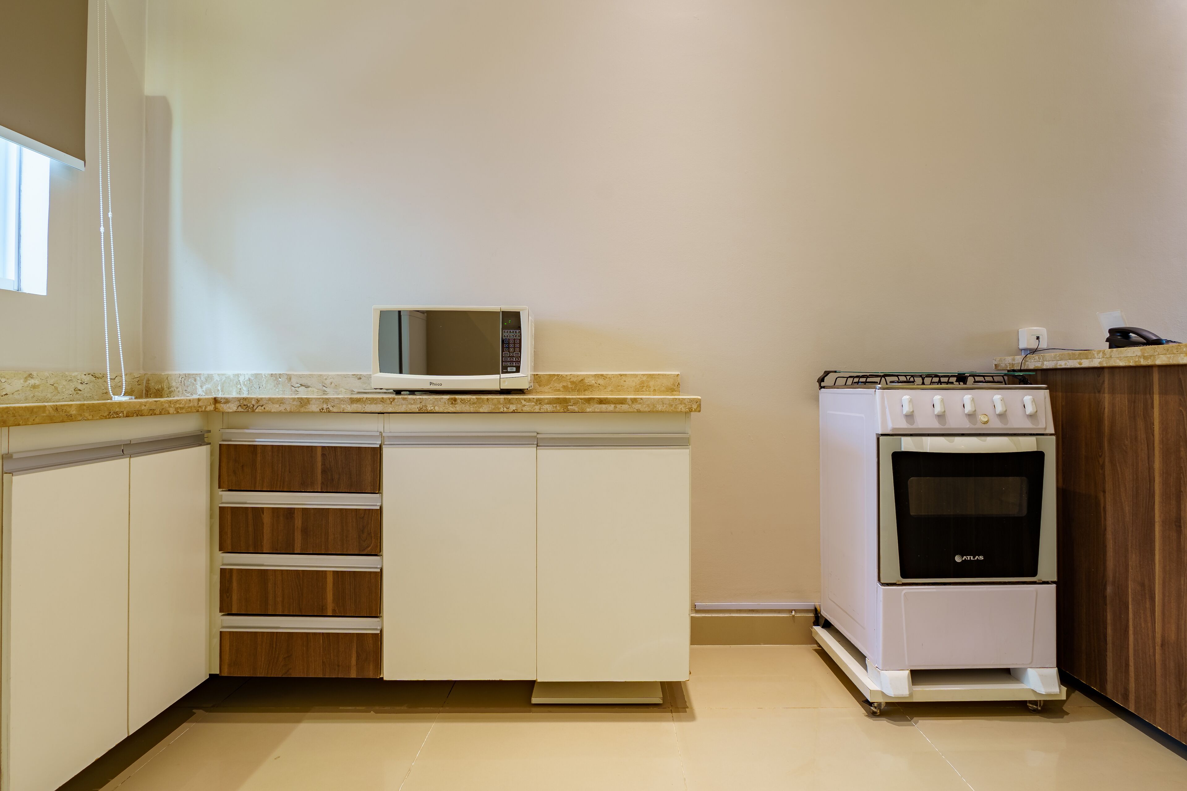 Una cocina compacta con microondas, horno y armarios de madera.