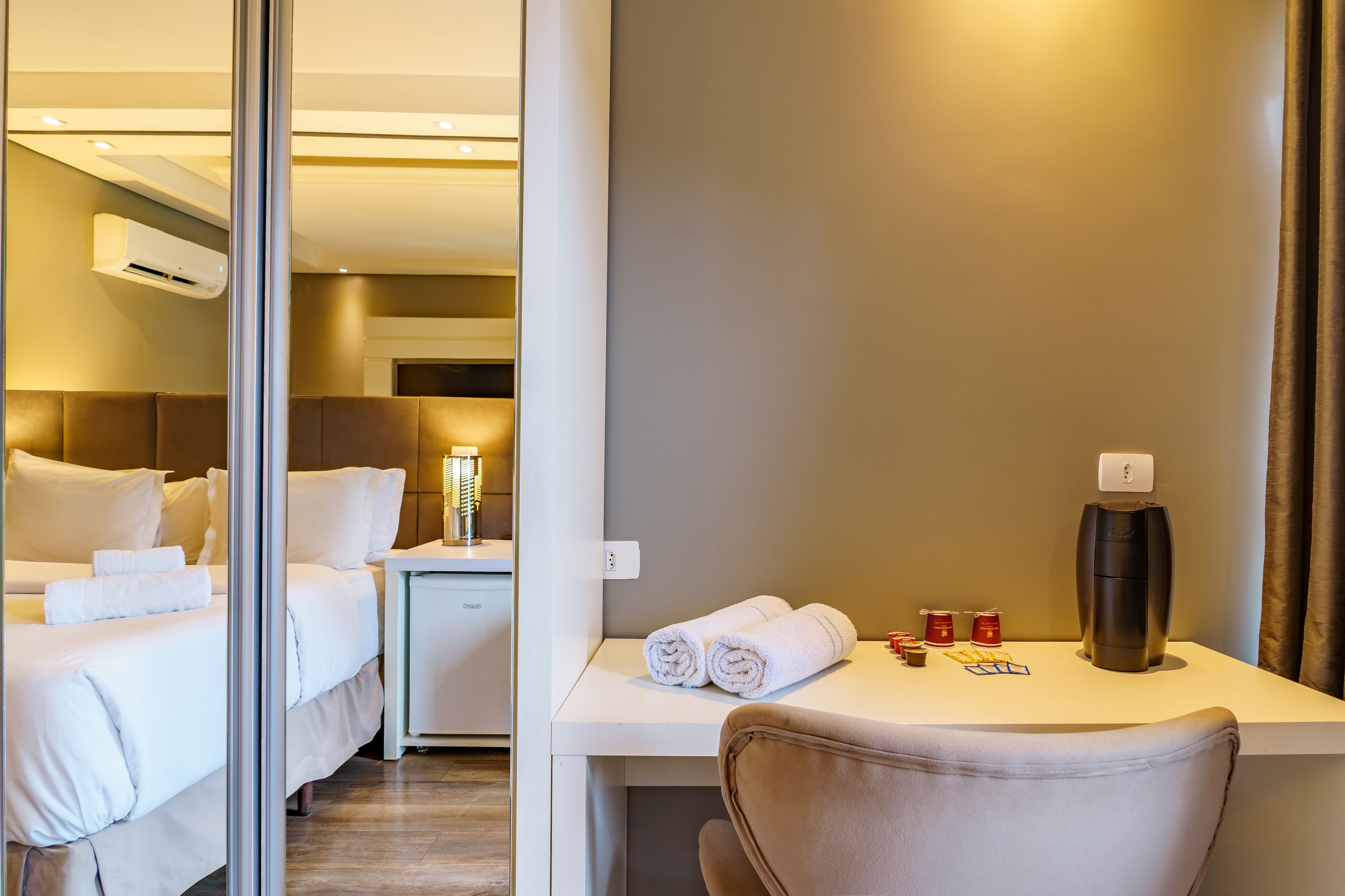 Una habitación de hotel con cama, mesita de noche y escritorio con silla.