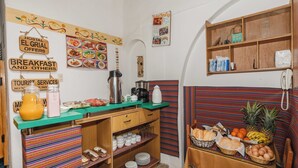 A kitchenette with a coffee maker, a kettle, and a fruit basket. - Hostal El Grial (Cusco)