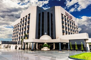 Un hotel grande con diseño moderno, que cuenta con una cúpula central y varios balcones.