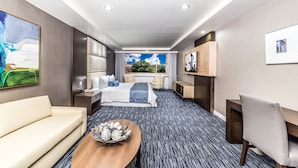 Una habitación de hotel con cama, sofá, mesa de centro y escritorio.