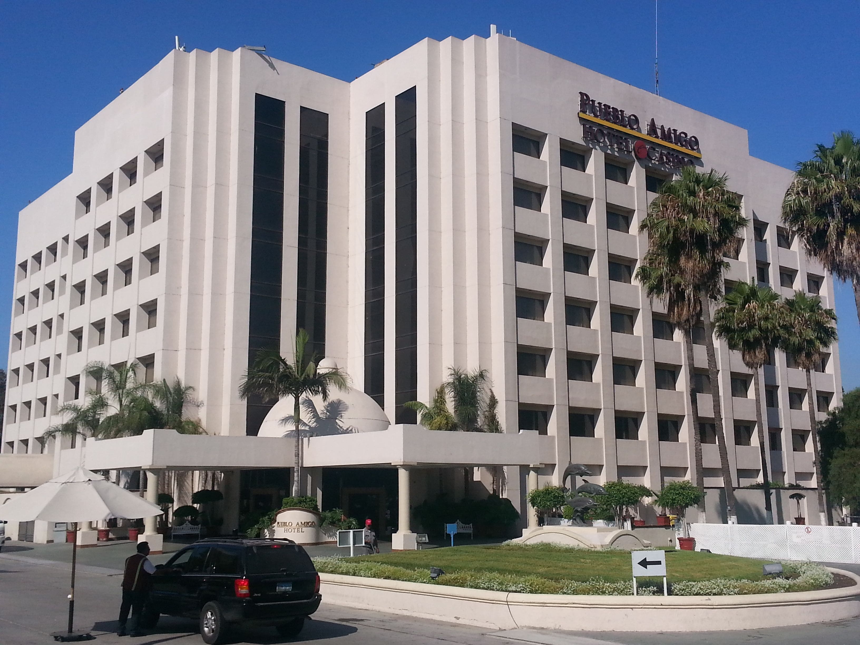 Un gran edificio de hotel con diseño moderno, con varios pisos y una entrada destacada.