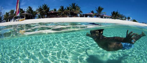 On the beach, white sand, sun loungers, beach umbrellas