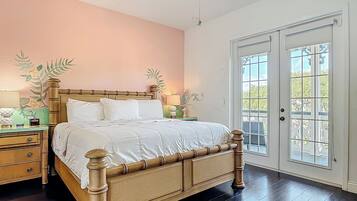 Une chambre à coucher avec un lit en bois, une table de chevet, une lampe et un mur décoré de motifs floraux.