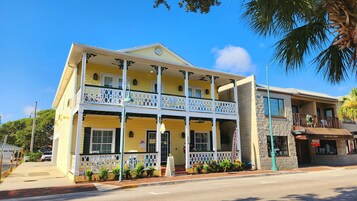 A two-story yellow building with a balcony, a sign for 'Inn on the Ave', and a 'Courtyard Grill' adjacent to it.