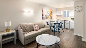 A modern living room with a sofa, coffee table, and dining area. - Hotel McCoy Pullman - Art, Coffee, Beer, Wine (Pullman)