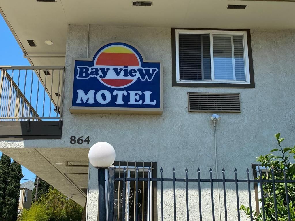 Een motelbord met de naam 'Bayview Motel' en het nummer '864' op de gevel.