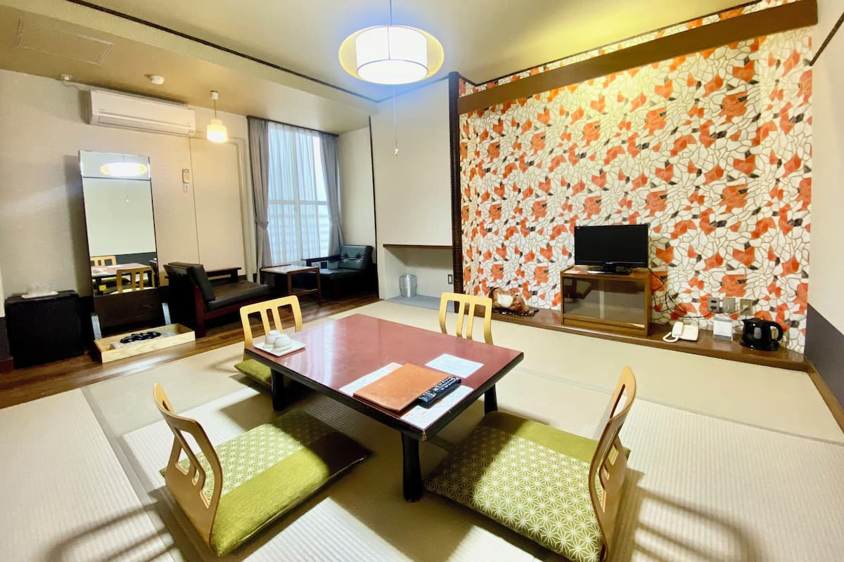 Um quarto tradicional japonês com piso de tatame, uma mesa baixa e biombos de papel.