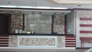Una mesa de recepción en Vista Marina Hotel & Resort, con una pared de azulejos y un letrero encima.