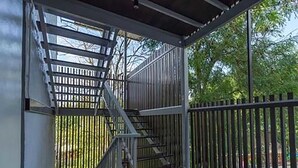 A covered outdoor staircase with metal railings, leading to a higher level. - A Plus Hotel Koh Lipe - Hostel (Koh Lipe)