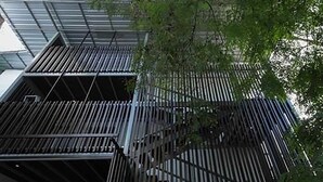 A modern building with a metal facade and a staircase leading to an upper level. - A Plus Hotel Koh Lipe - Hostel (Koh Lipe)