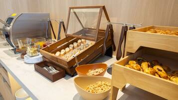 A buffet setup with various food items and utensils.