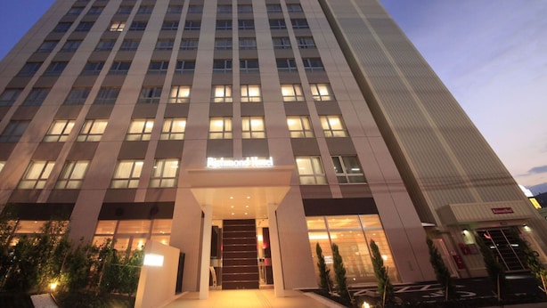 A tall hotel building with a modern design, featuring a prominent entrance and multiple floors. - Richmond Hotel Namba Daikokucho (Osaka)