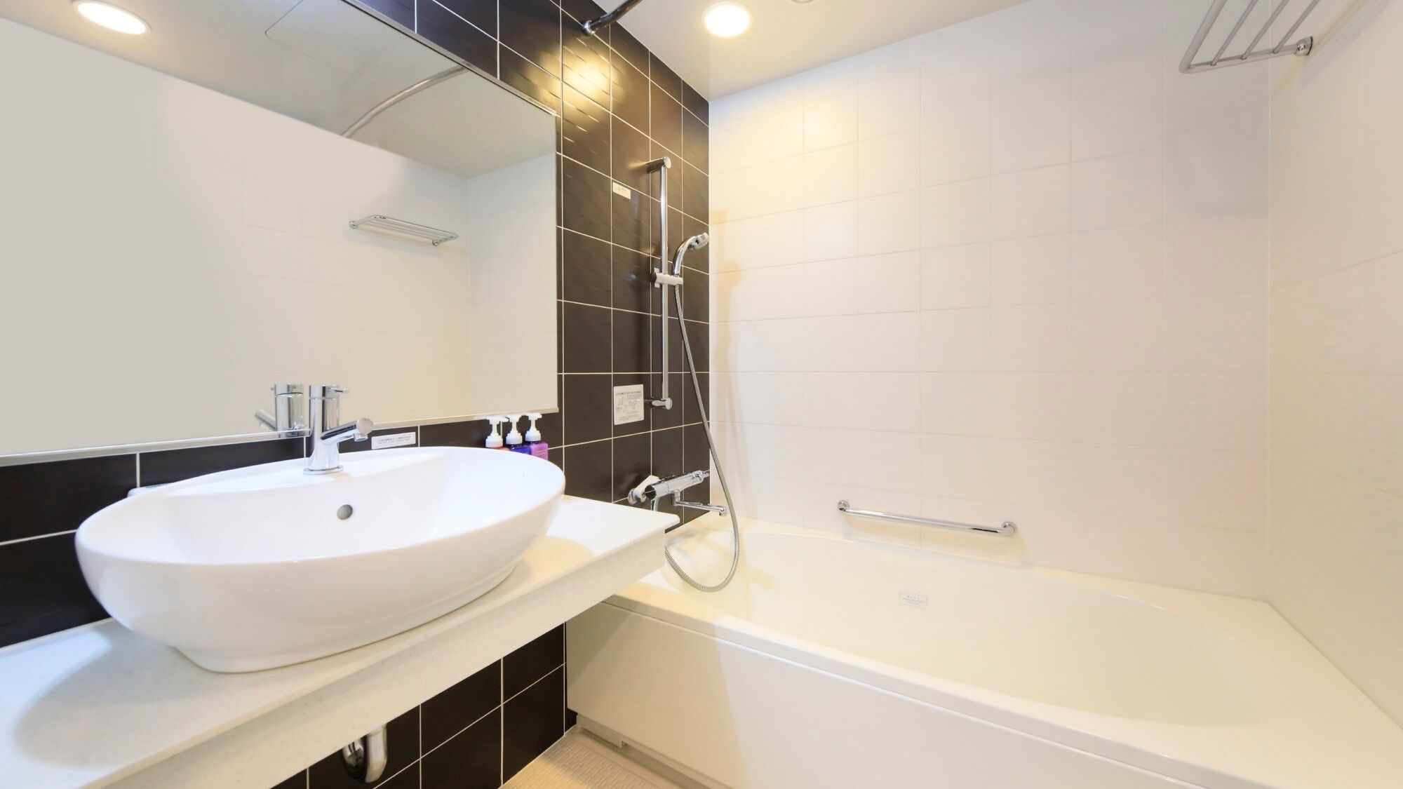 Un baño moderno con lavamanos blanco, bañera y ducha.
