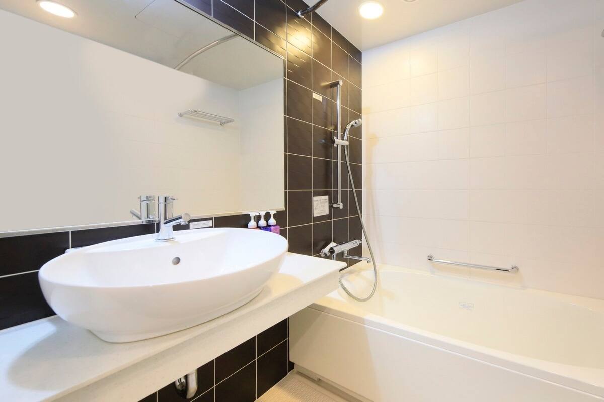 Une salle de bain moderne avec un lavabo blanc, une baignoire et une douche.