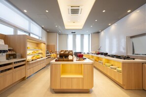 A modern kitchen with wooden cabinetry, a central island, and a view of the dining area.