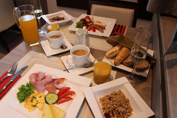 A breakfast setting with plates of food, drinks, and cutlery. - Boutique Hotel Villa ZAUBER (Poprad)