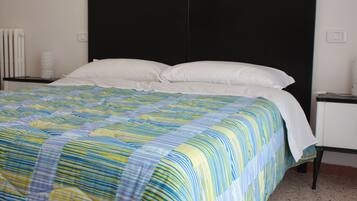 A bed with a striped bedspread, a black headboard, and white pillows.