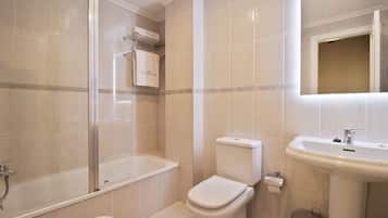 Een moderne badkamer met een bad, toilet en wastafel.