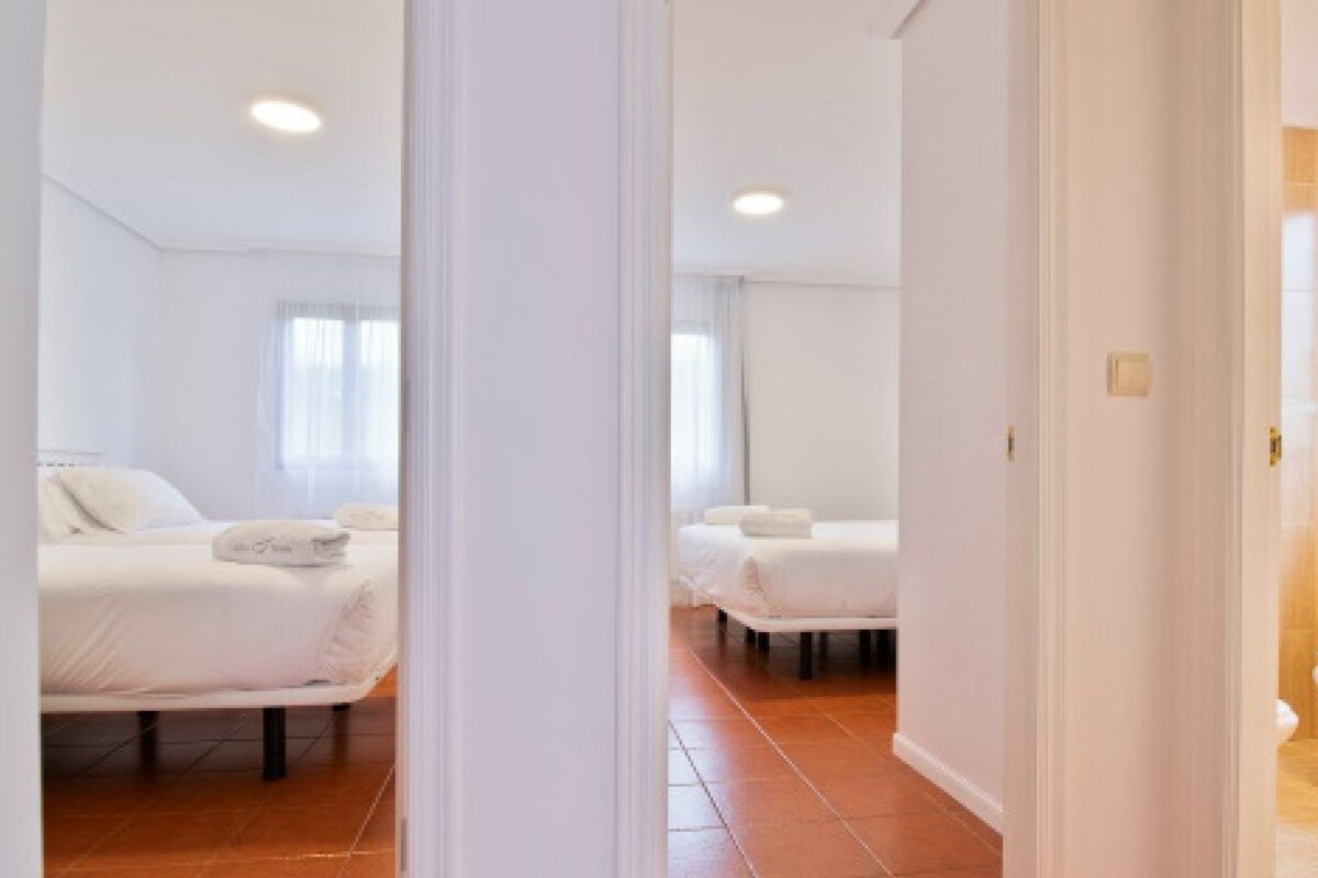 A hotel room with a bed, a bathroom with a toilet, and a shower area.
