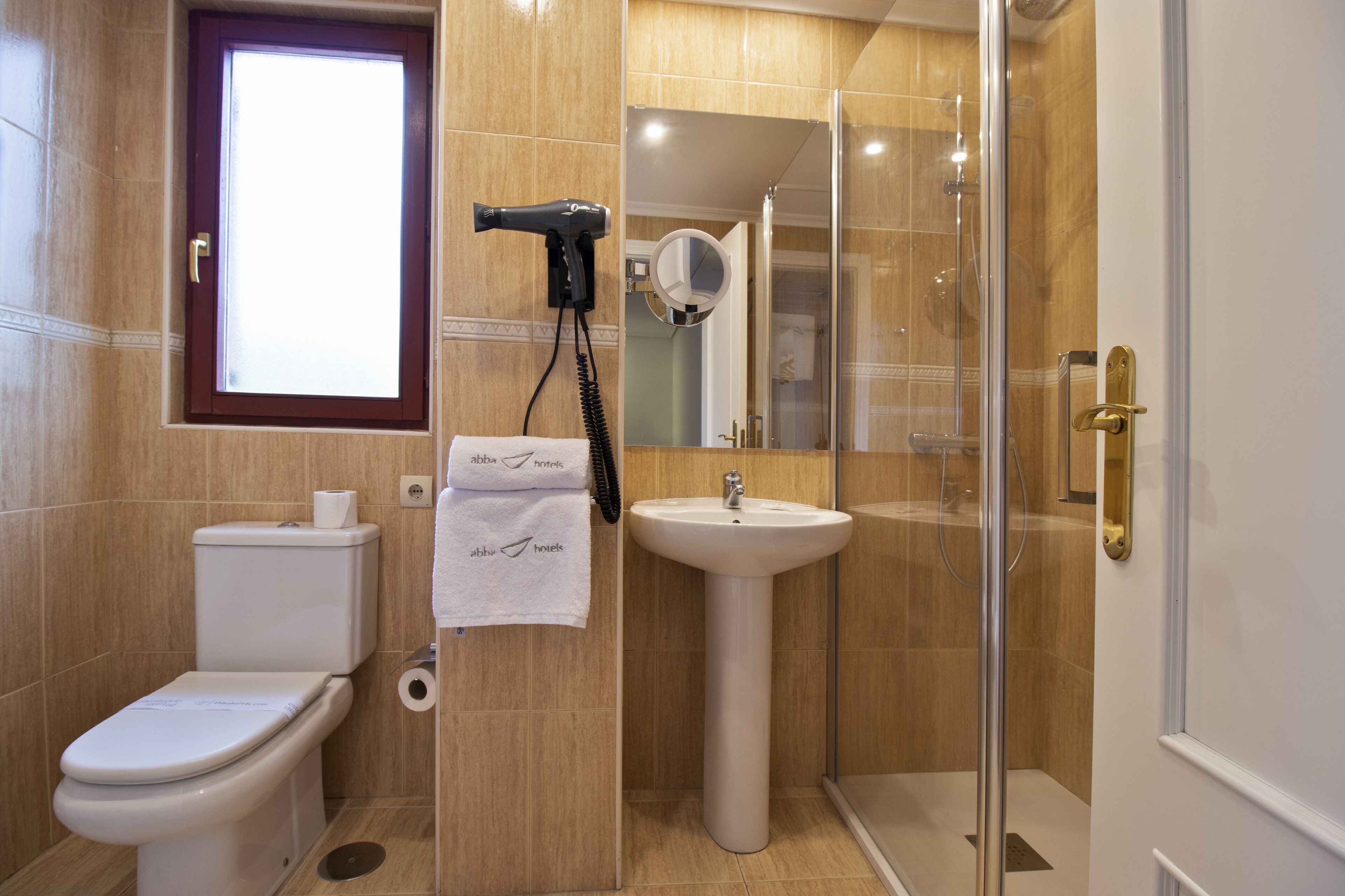 A bathroom with a toilet, sink, and shower.