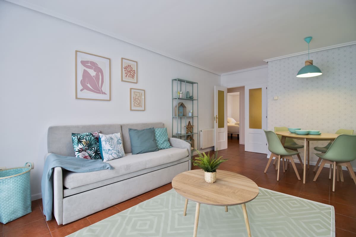 Una sala de estar moderna con sofá, mesa de centro y comedor.