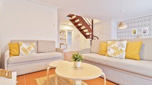 A modern living room with two sofas, a coffee table, and a staircase. - Abba Comillas Apartments (Comillas)