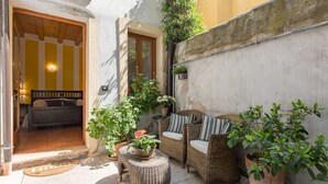 Un espacio al aire libre acogedor con mobiliario de mimbre y plantas en macetas.