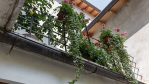 Un balcón con macetas y flores.