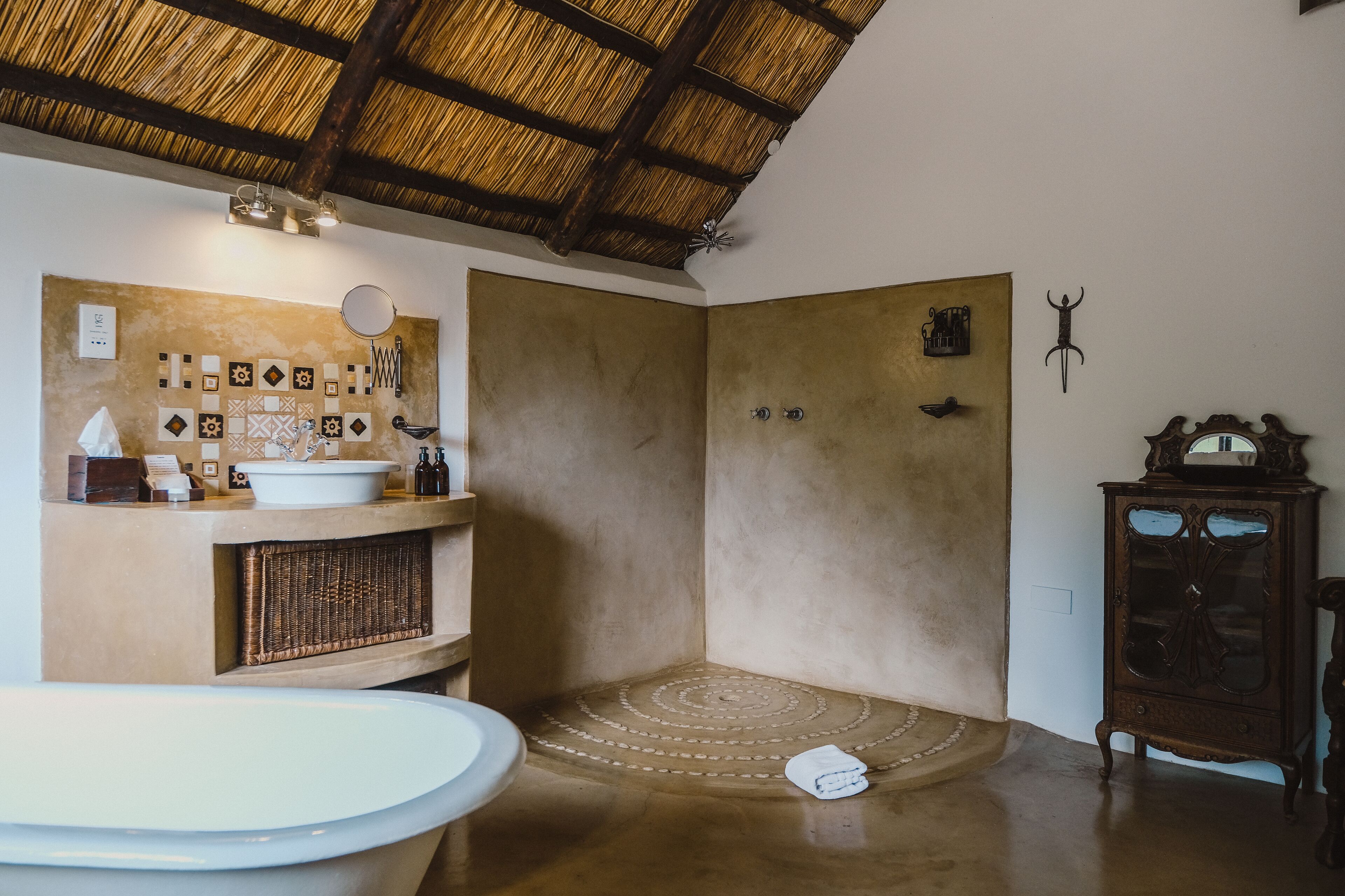 Ein Badezimmer mit einer großen Badewanne, einer Dusche und einem Waschtisch mit Spiegel und Handtuchhalter.
