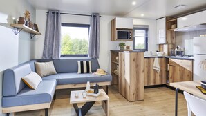 A modern apartment with a living area, kitchenette, and a dining space. - Camping Les Castors (Calvi)