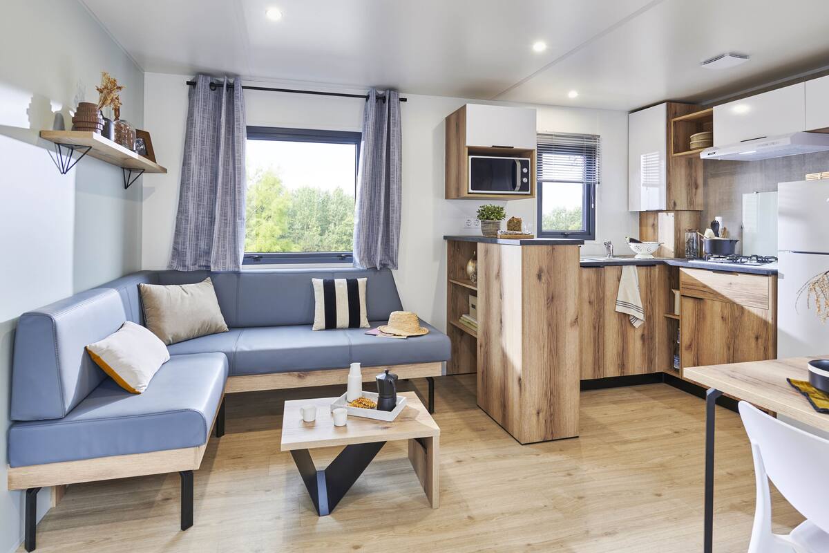 A modern apartment with a living area, kitchenette, and a dining space.