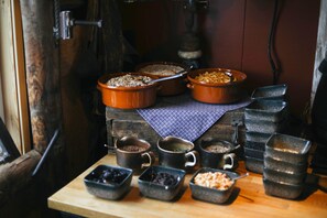 A rustic kitchen with various cooking utensils and containers on a wooden table. - Mary-Ann's Polarrigg (Longyearbyen)